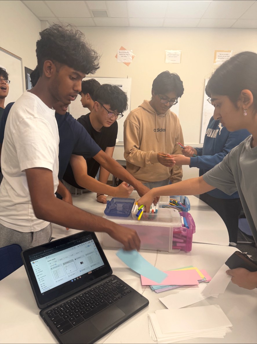 Students gathered at a SENIOR CARE UNITED table in a high school